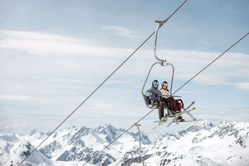 Skifahrer auf dem Sesselift am Arlberg